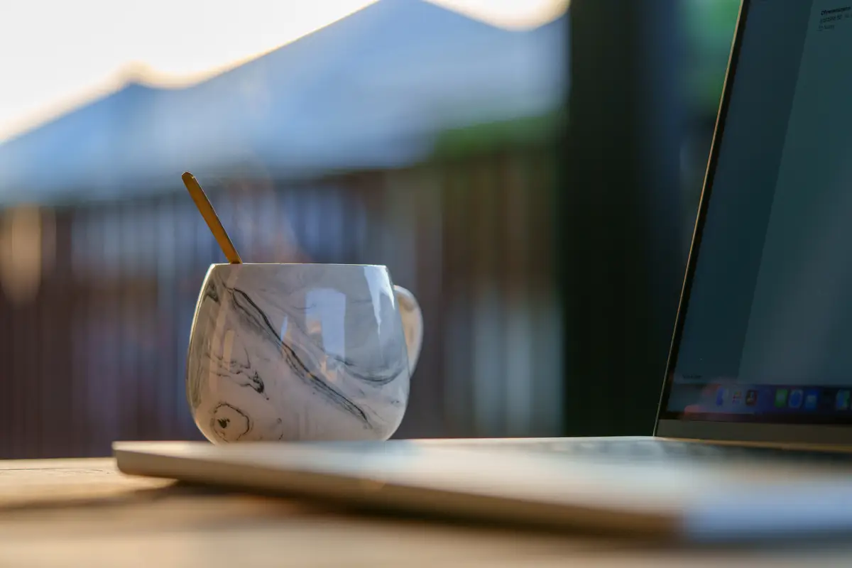 Laptop with black blank screen on a wooden desk