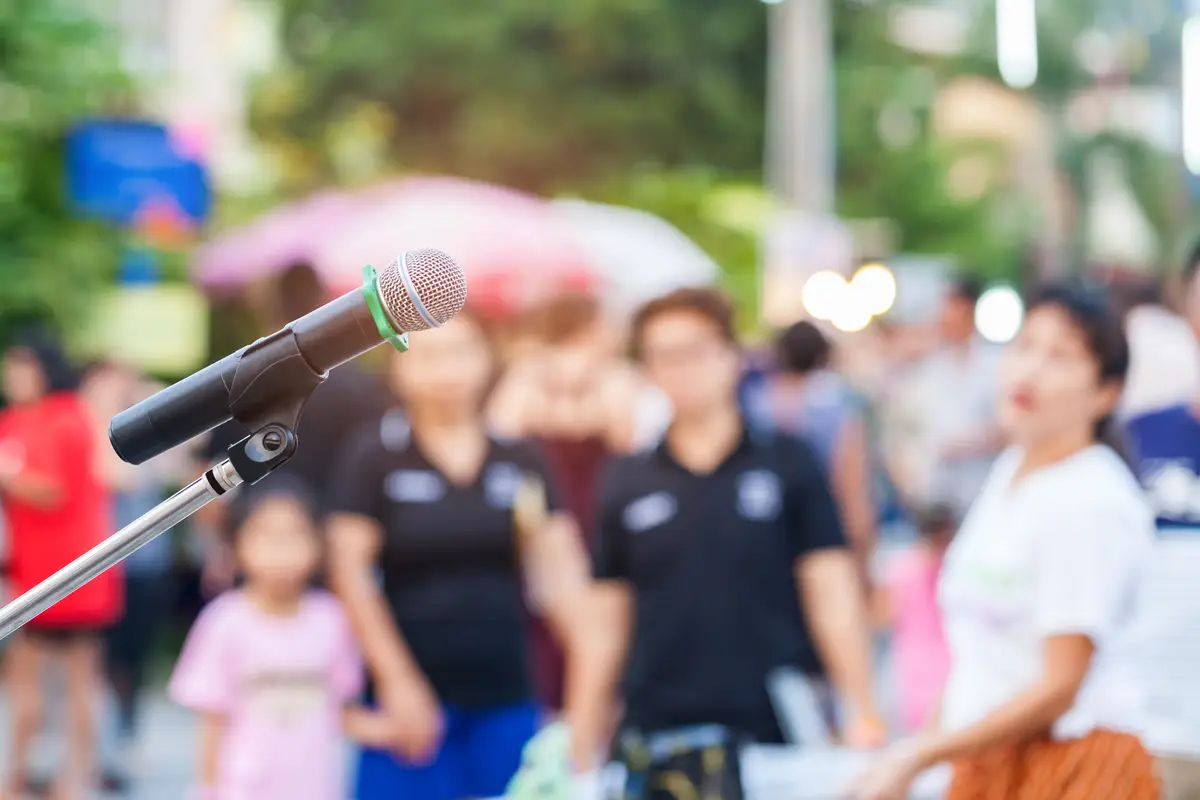 Close-up of microphone with people in background