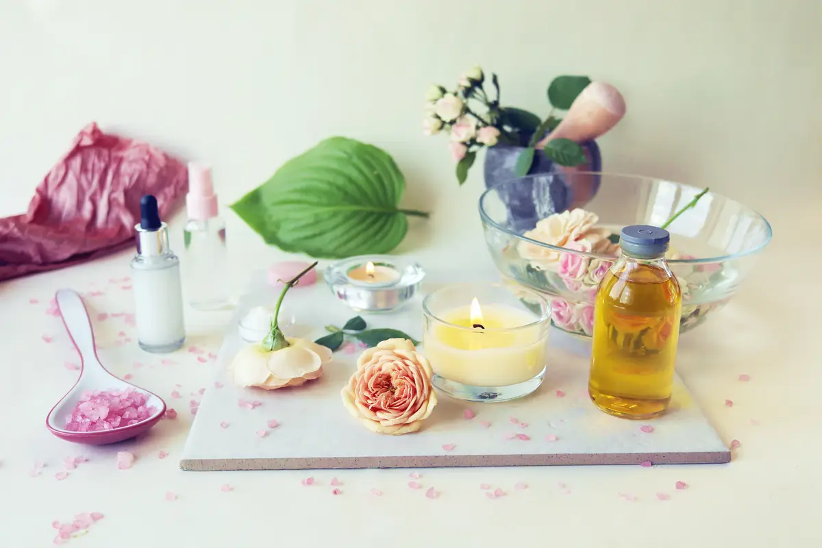 Spa fresh pink roses burning candles oils and tinctures on a light background healthy lifestyle
