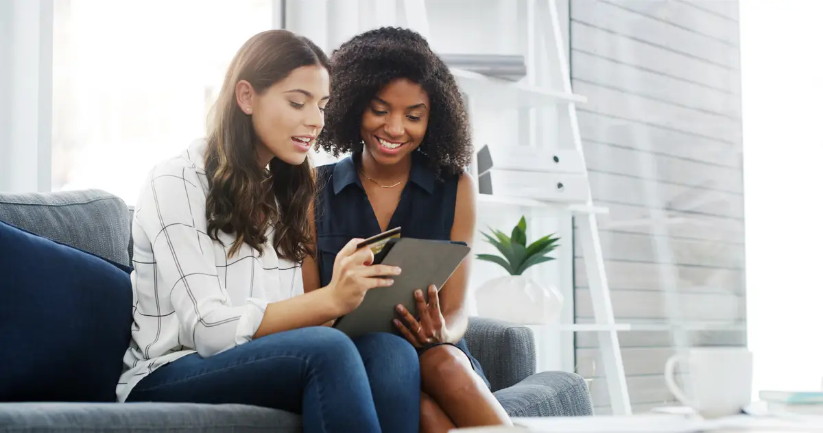 Tablet home and couple of friends with credit card for online shopping banking and discount Debit technology and women together in living room for payment ecommerce order or financial purchase