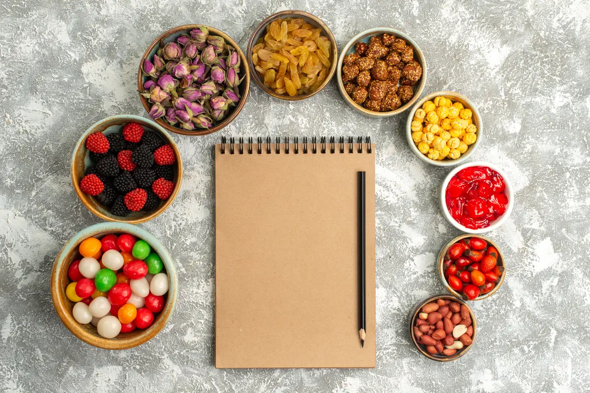 Top view different sweets candies raisins and nuts on a white background candy sugar goodie biscuit