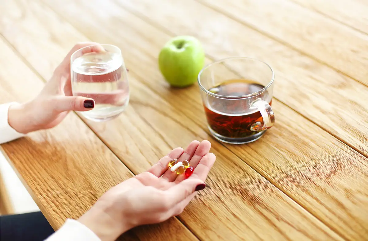 Midsection of woman holding glass of juice