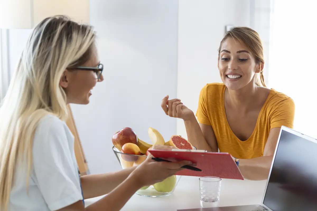 Female nutritionist giving consultation to patient Making diet plan in weight loss clinic