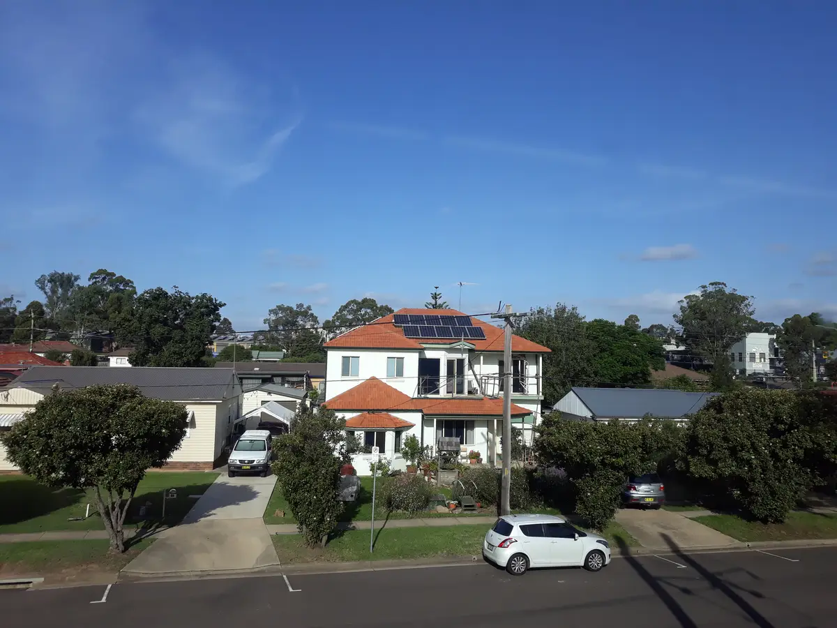 Cars on road by buildings against sky