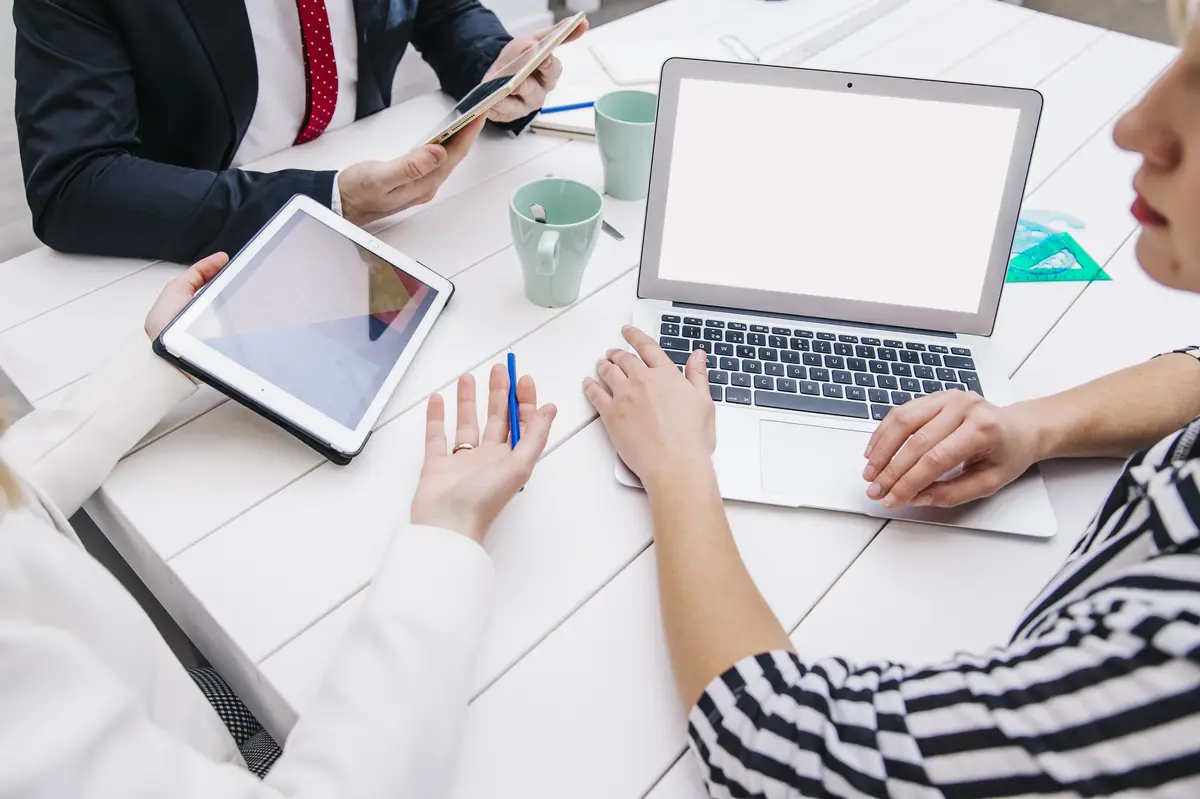 Colleagues with devices at working desk