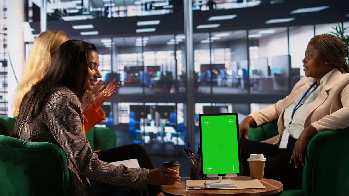 Group of professionals using isolated chroma key on tablet in a meeting