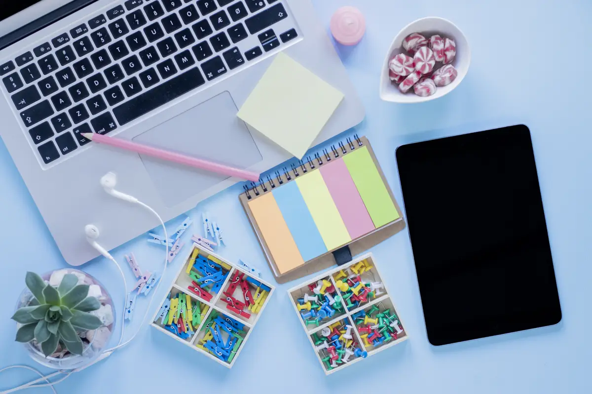 Stationery and candies near tablet and laptop