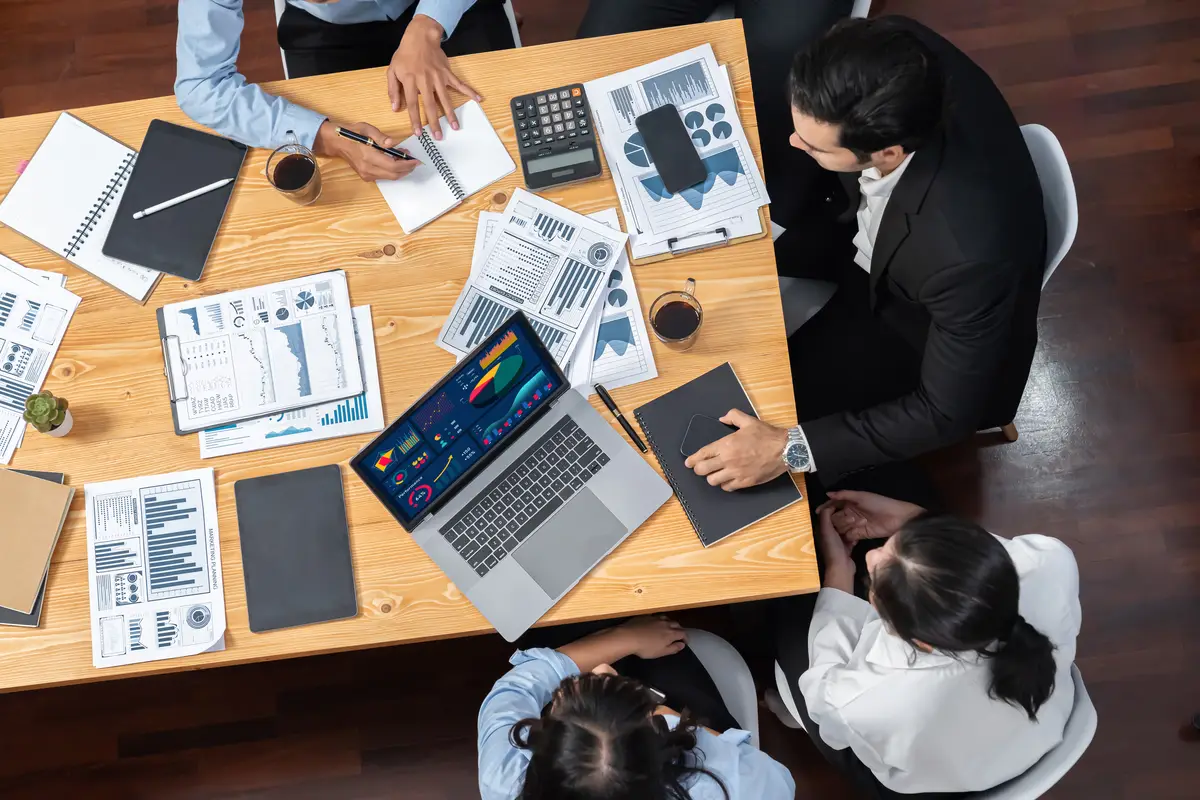 Wide top view diverse analyst team analyzing financial data Meticulous