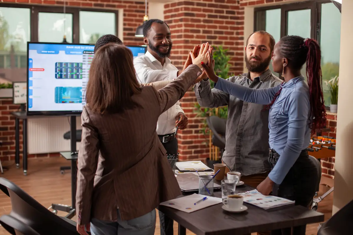 People stand and high five in office