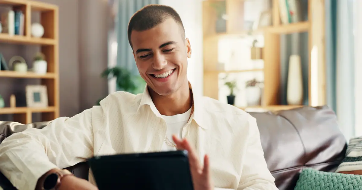 Home sofa and man with laughing for tablet online news and reading information for blog in living room House male person and scroll with digital for social media application and ebook on couch