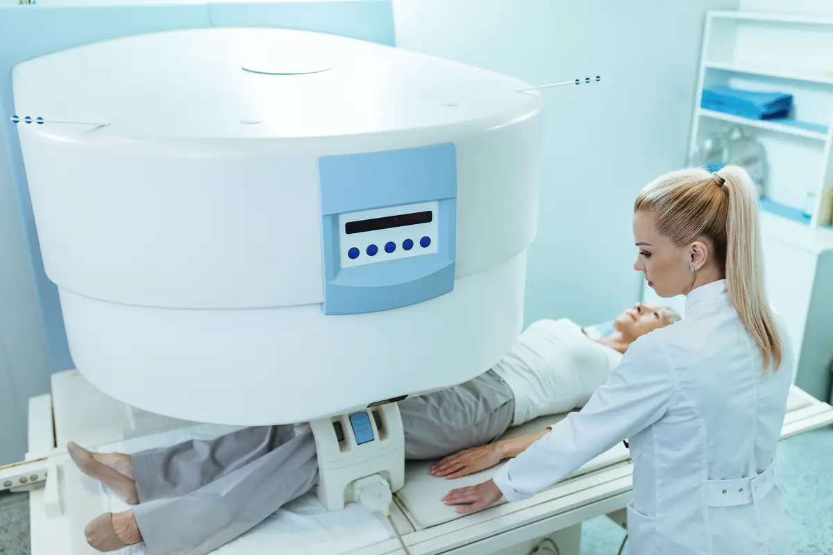 High angle view of female radiologist and mature patient during knee MRI scan procedure in the hospital