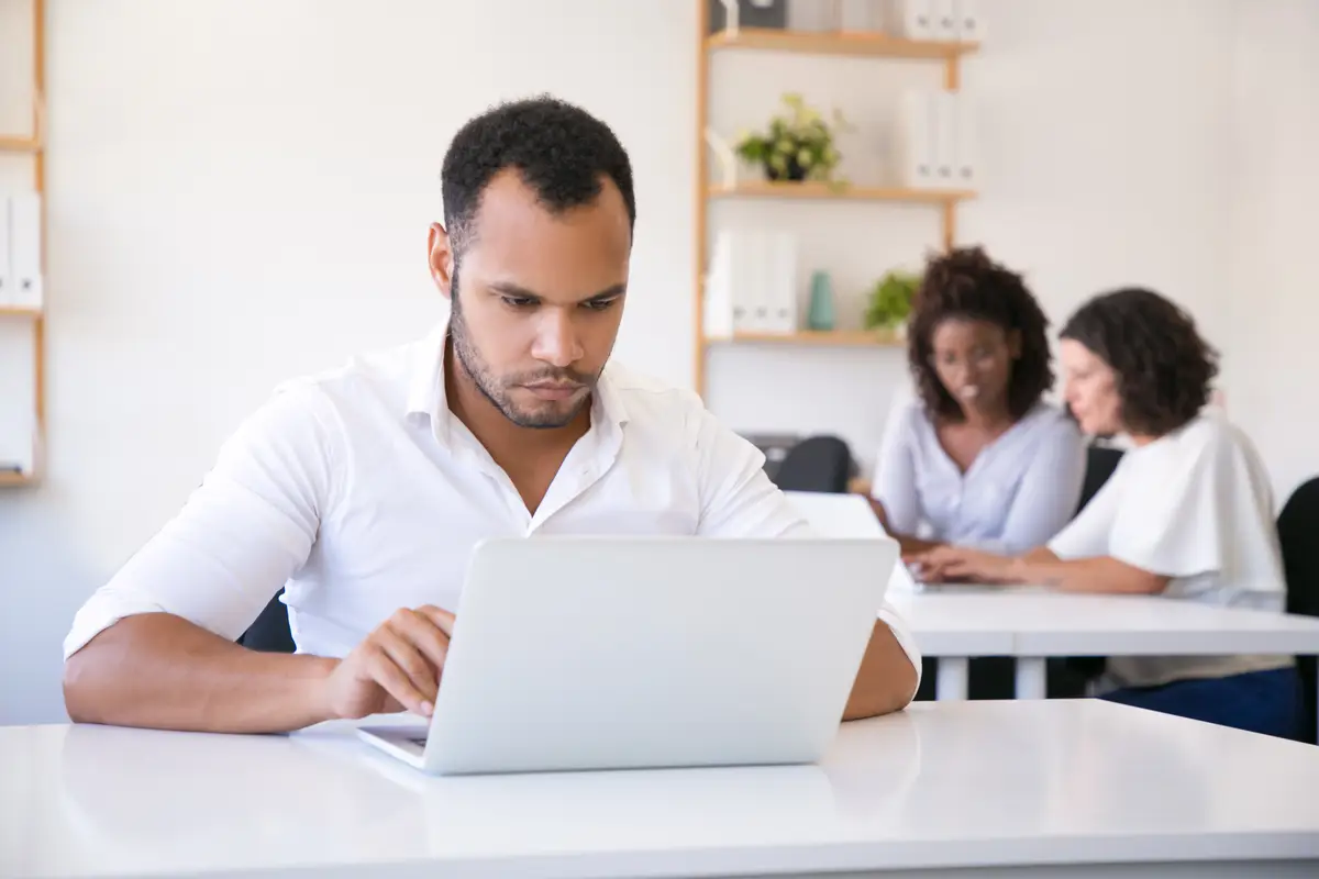 Focused male employee using laptop in office