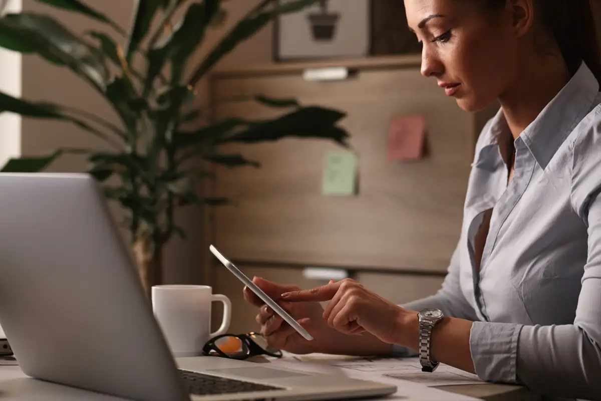Young businesswoman working on touchpad and surfing the net at her office desk