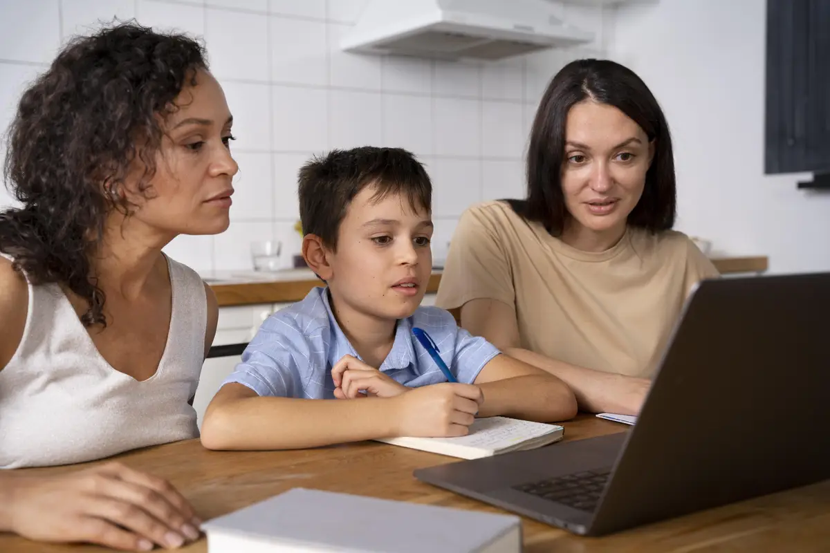 Lesbian couple helping their son to do his homework
