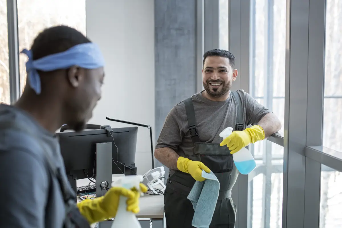 Medium shot men cleaning office together