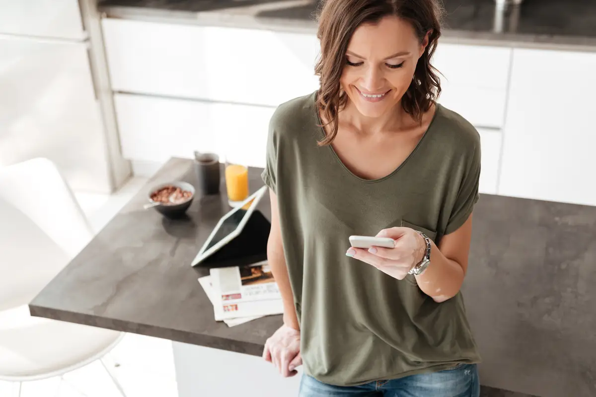 Smiling woman texting on mobile phone