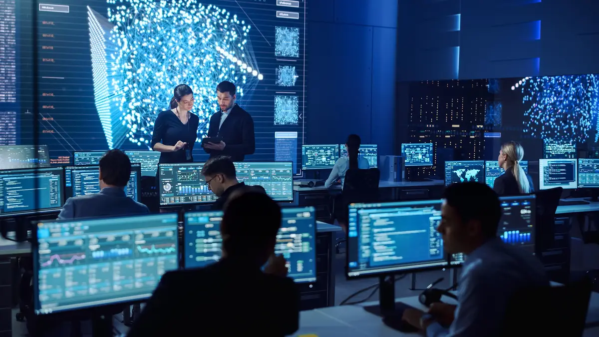 A group of people in a computer lab with the words code on the screen