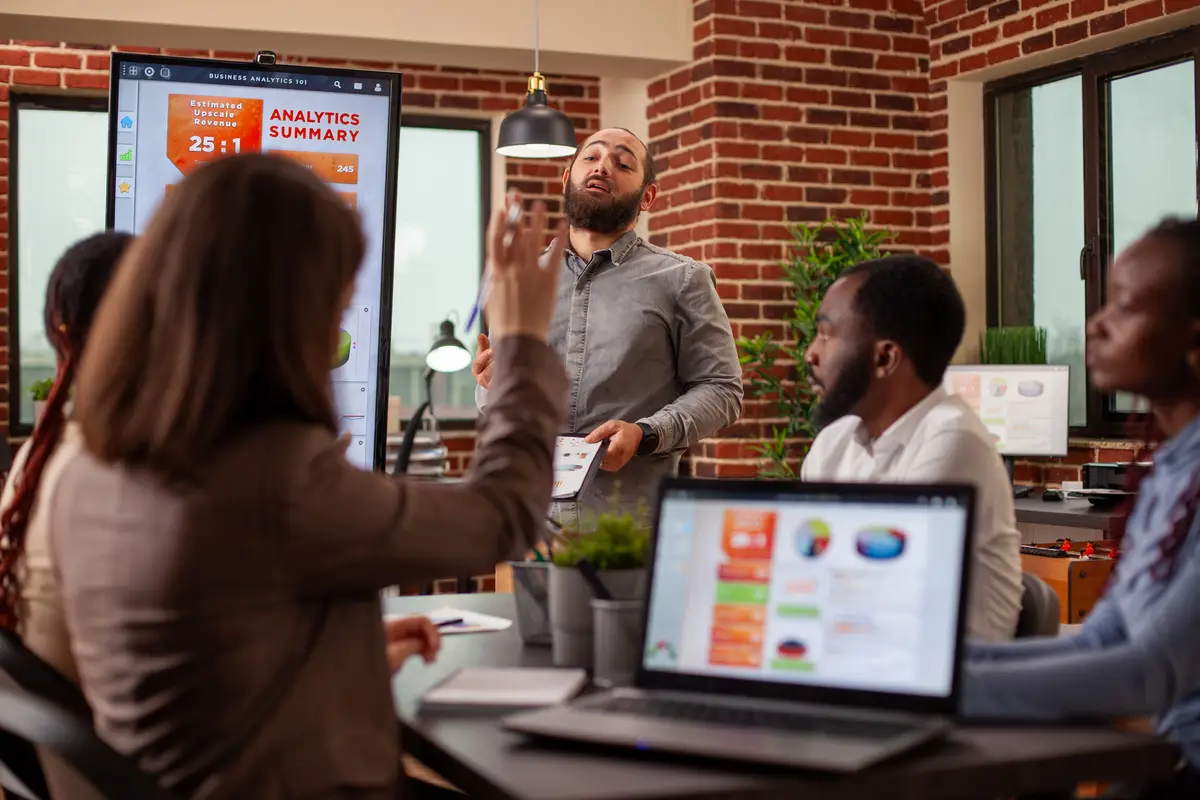 Bearded man answers questions in meeting