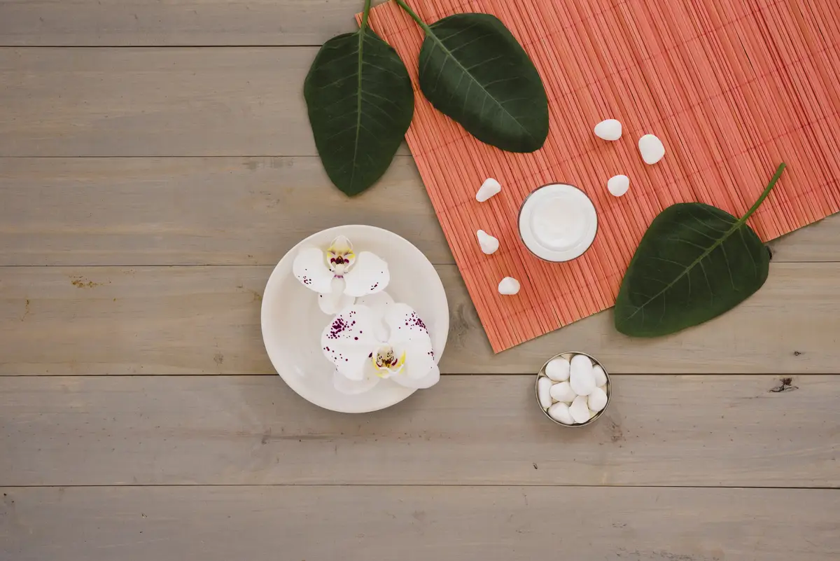 Spa tools with green leaves placed on wooden table