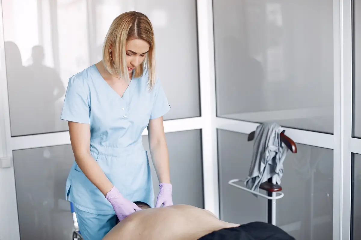 The doctor massages the man in the hospital