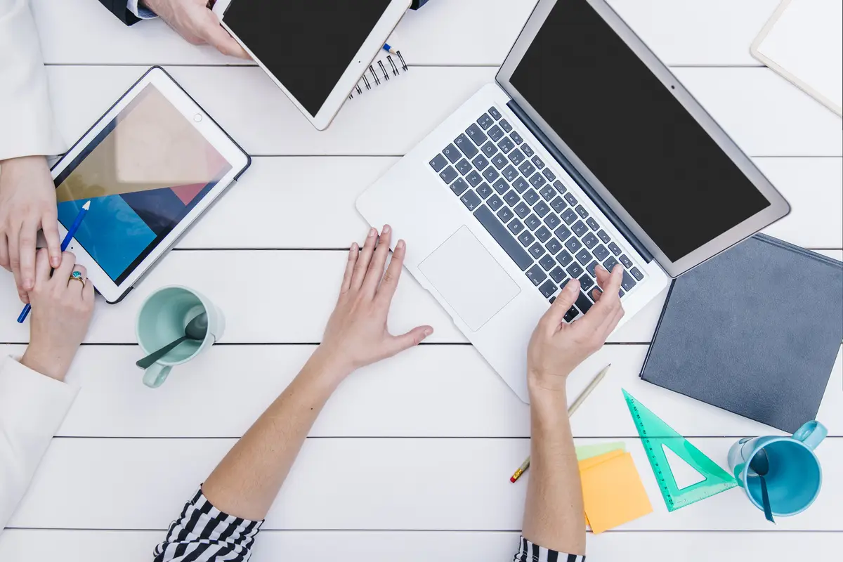 Anonymous woman showing laptop to colleagues