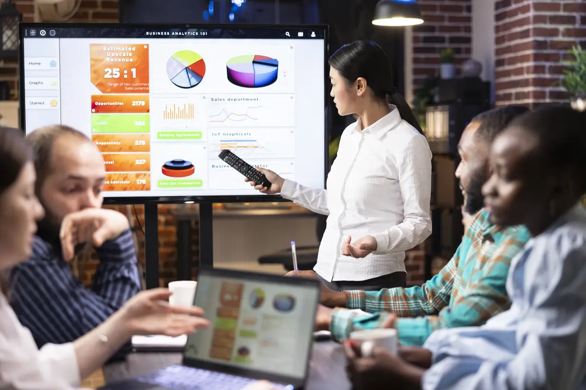 Asian manager discussing business analytics with team