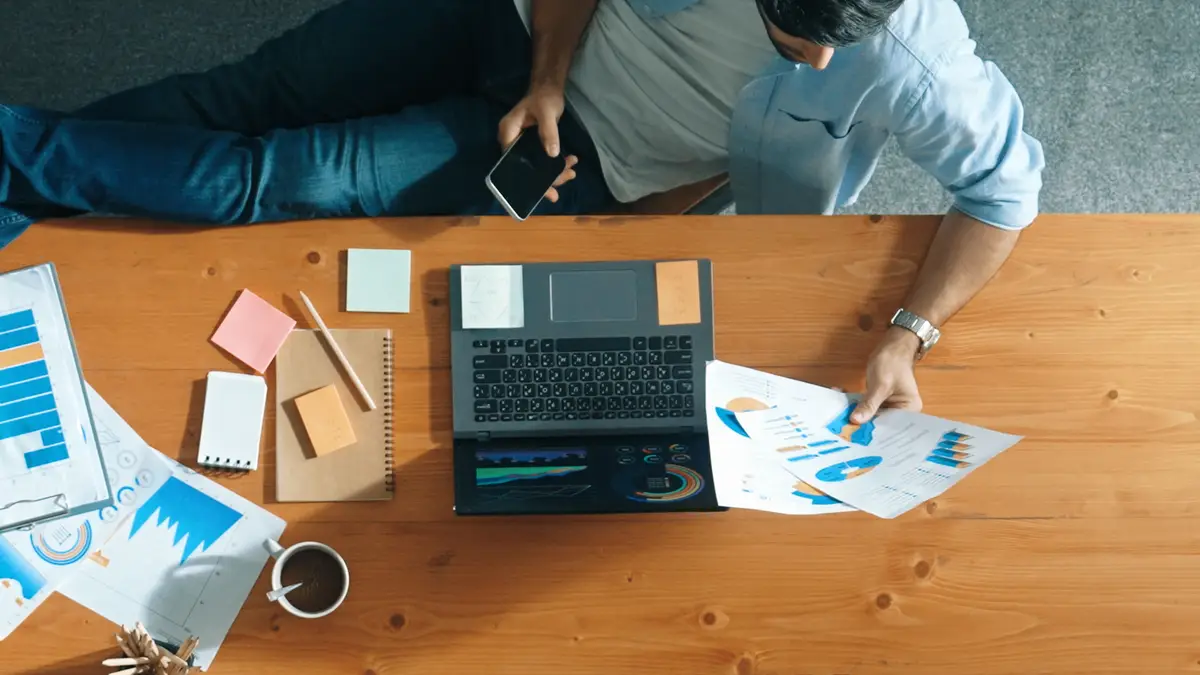 Smart businessman looking at phone while sit and put leg on table convocation