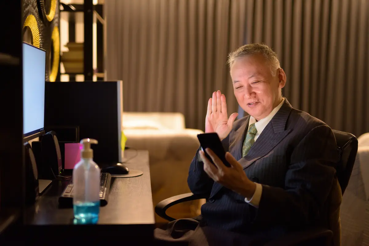 Man using mobile phone while sitting on table