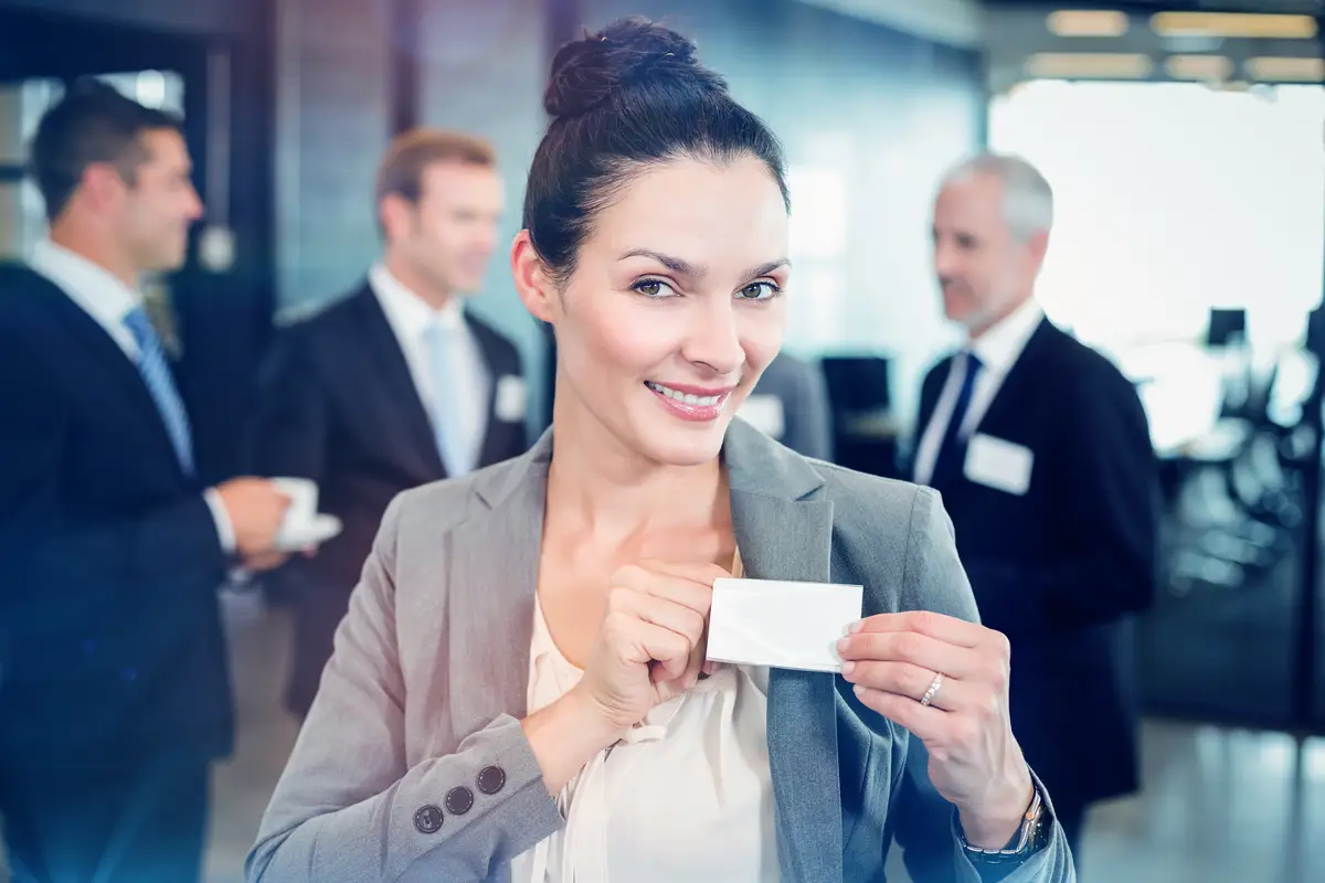 Businesswoman showing her badge while her colleague interacting in background