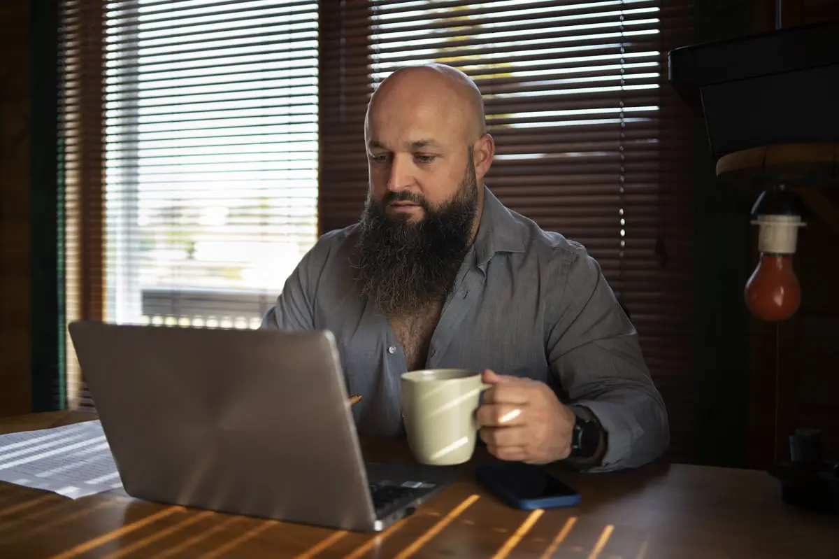 Medium shot man working on laptop