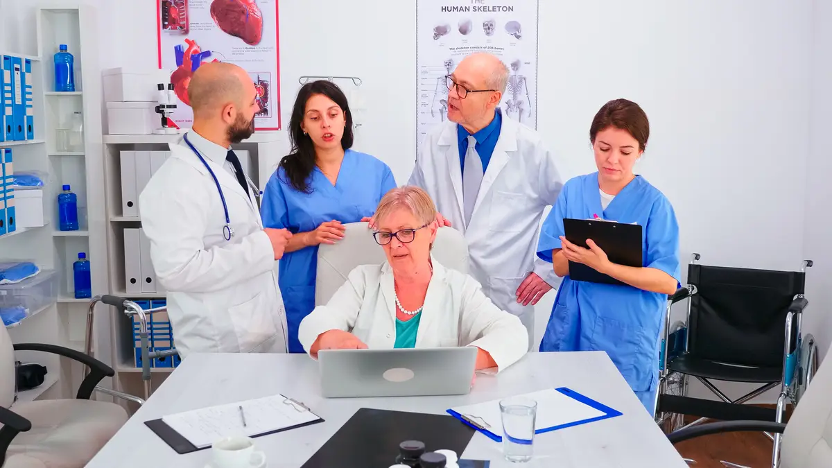 Abordagem multidisciplinar da endocardite em usuários de drogas injetáveis 2 Mature doctor specialist briefing her medical team in conference room using laptop. Medical team, teamwork people discussing diagnosis about patients treatment issues record in workplace.