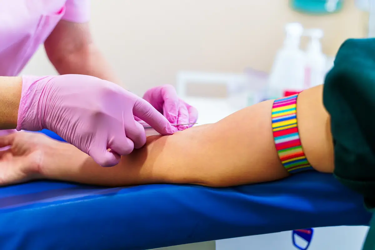 Nurse's hands taking a blood on isolated over laboratory room background.