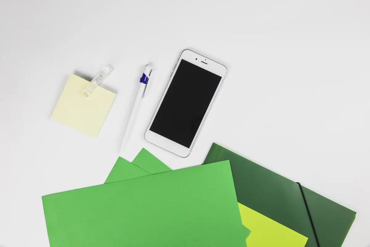 Smartphone with stickers and pen on table