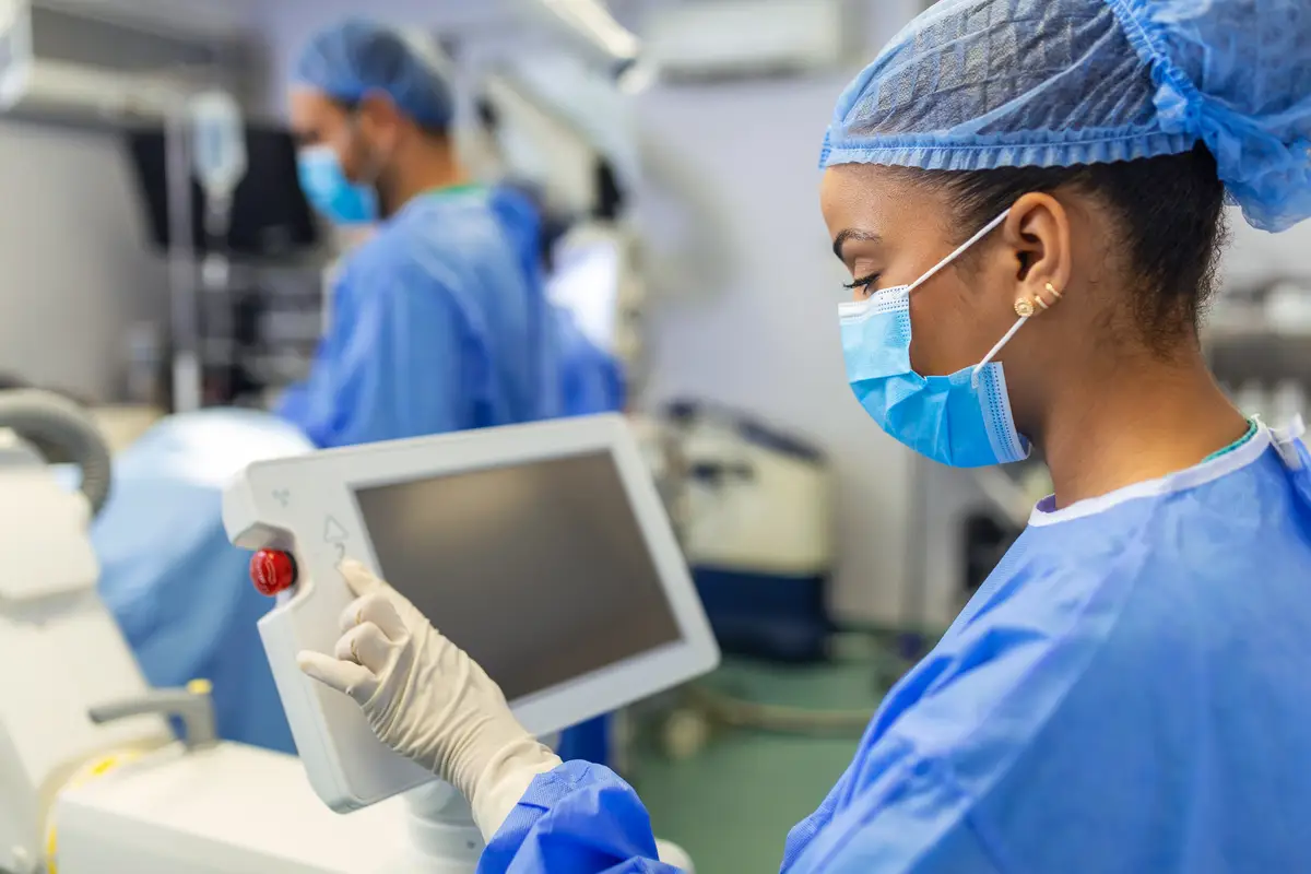 Female surgeon with surgical mask at operating room using 3d image guided surgery machine