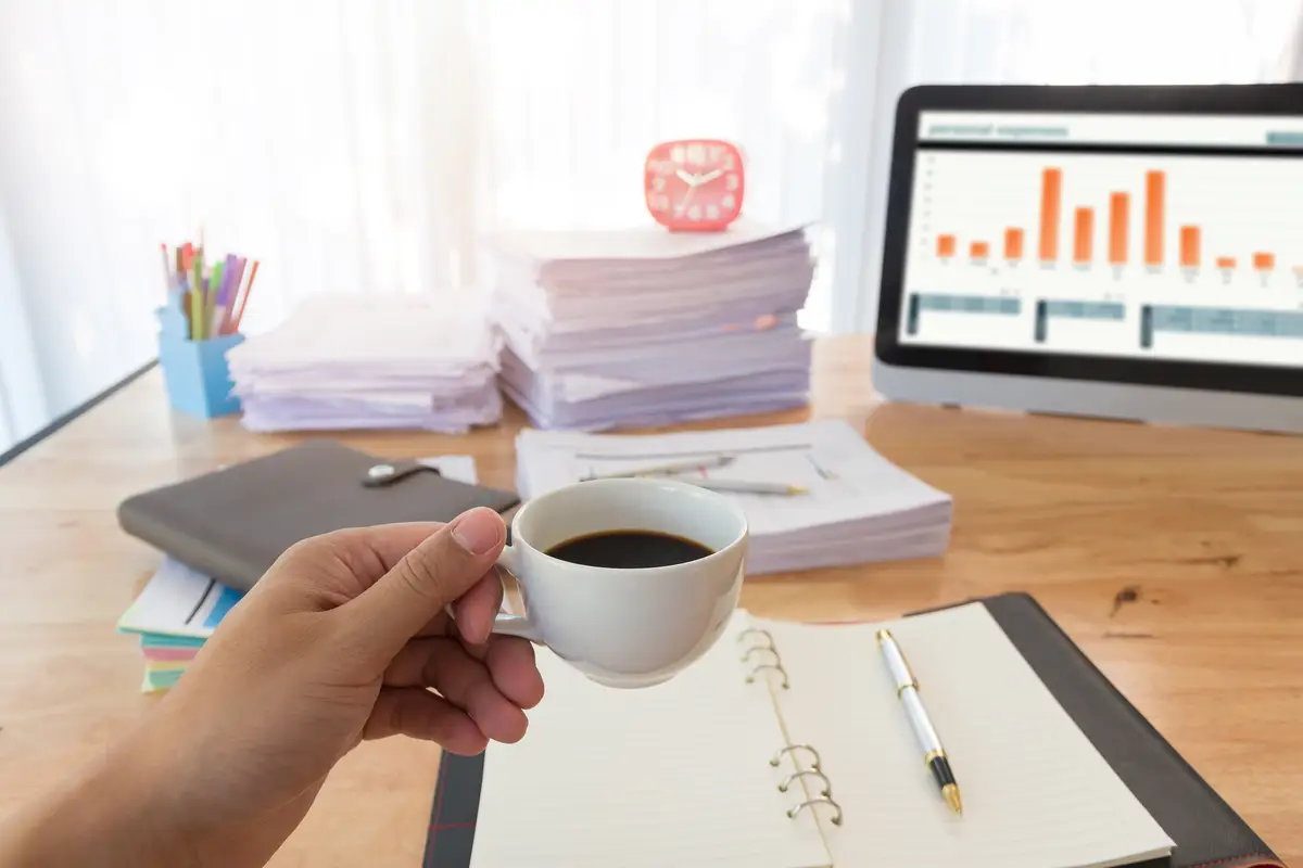 Hand holding coffee cup on table