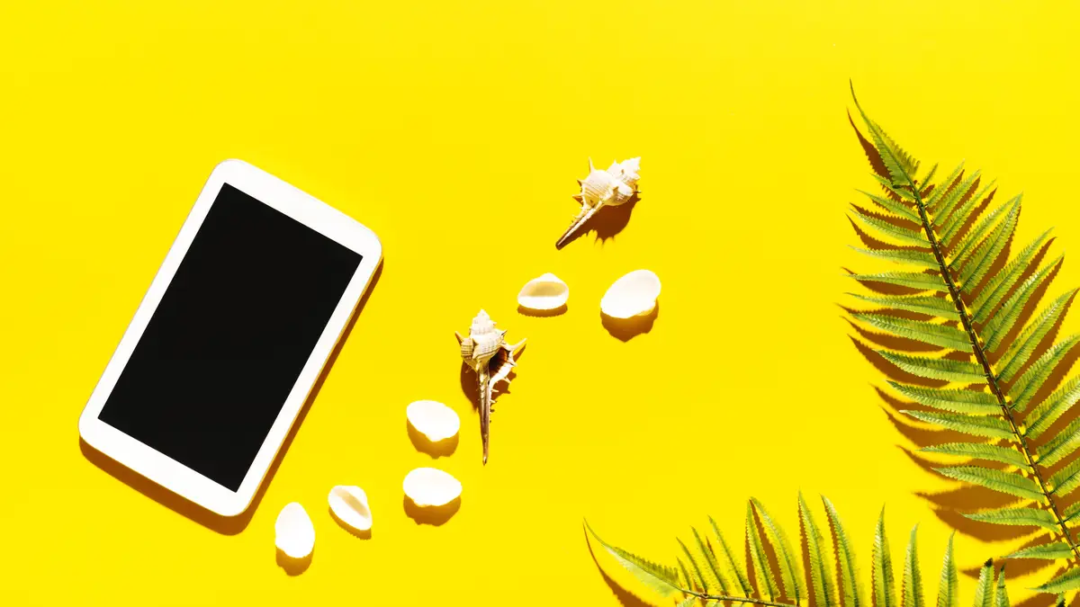 Tablet with shells on bright background
