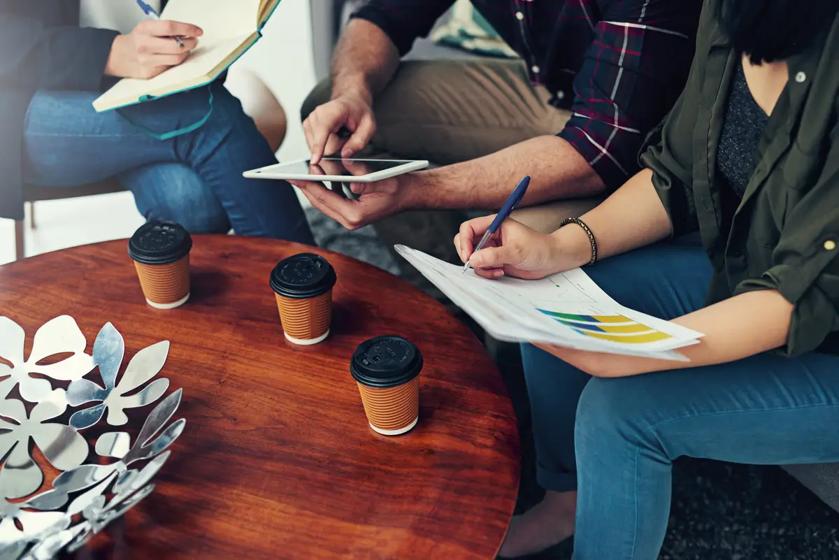 Hands group and business people planning with data statistics and tablet info in startup research Team collaboration or financial analyst brainstorming analysis of graph or writing notes on paper