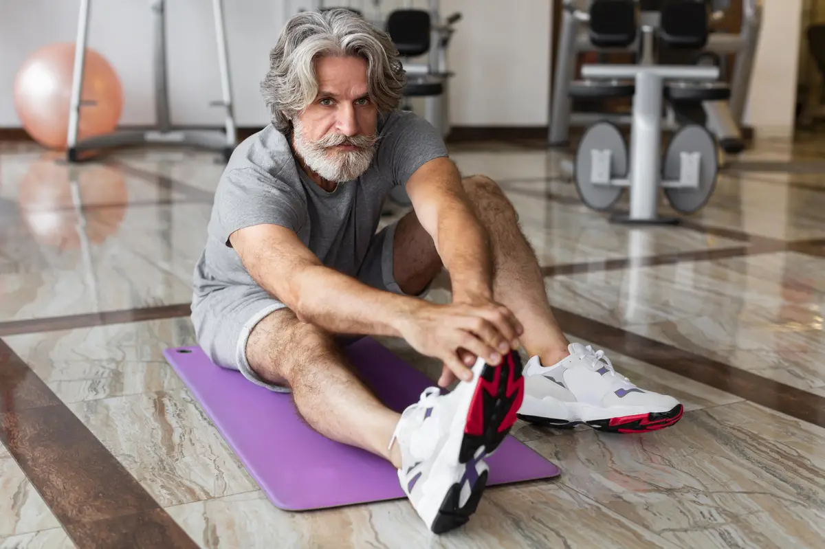 Full shot man stretching at gym