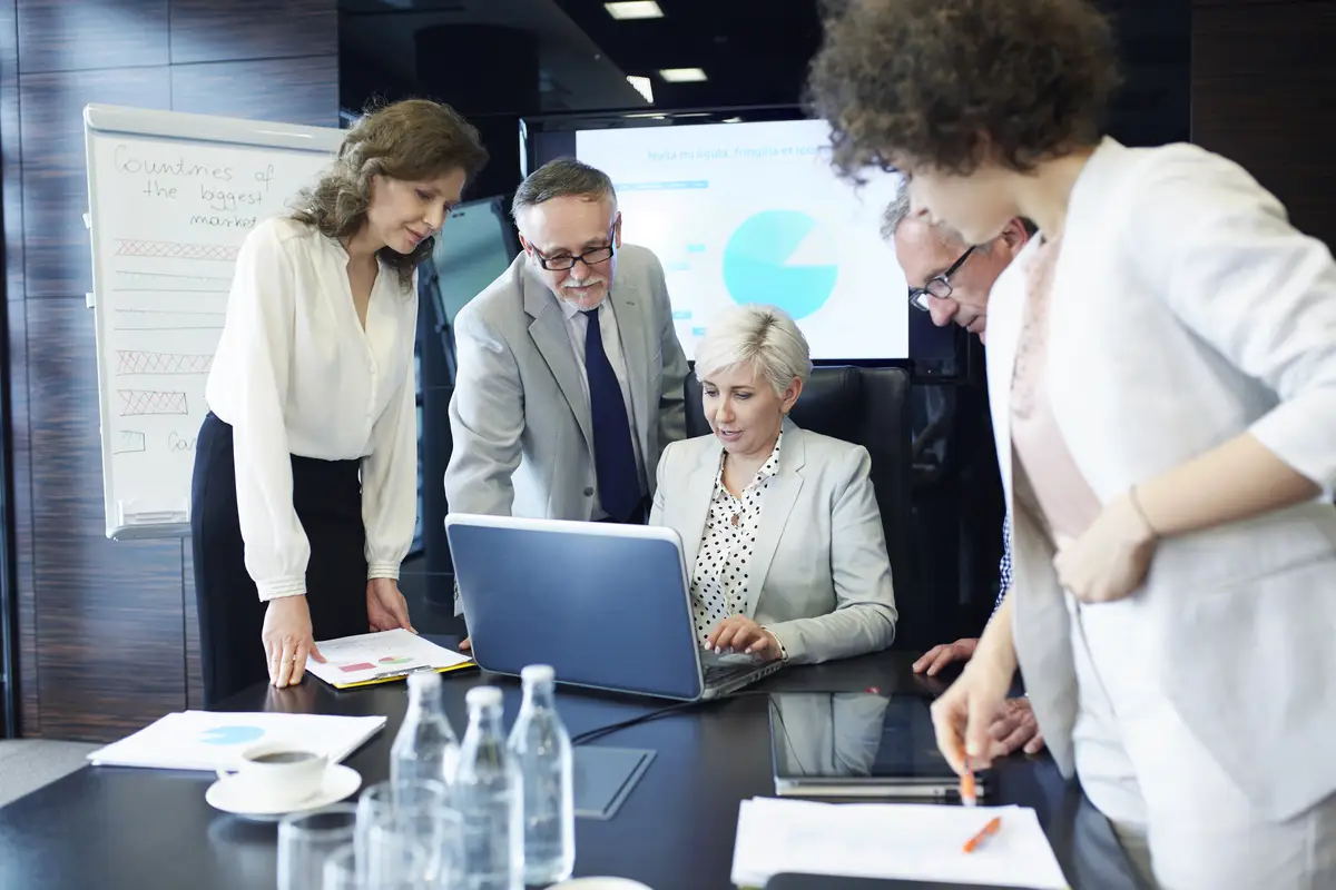 Business people with report working at laptop