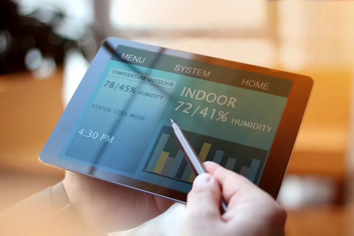 Man is Adjusting a temperature using a tablet with smart home app