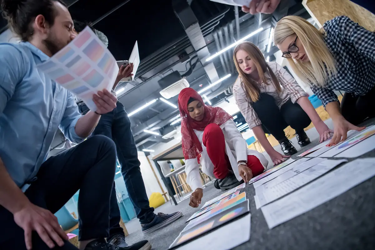 young black muslim businesswoman having meeting with her multiethnic startup business team in modern office interior,presenting new ideas on the floor