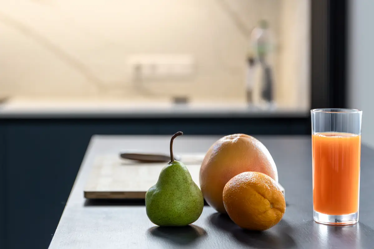 Fruits and juice by cutting board under led light healthy routine