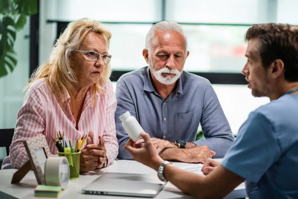 Senior couple discussing with doctor about prescription medicine during consultations