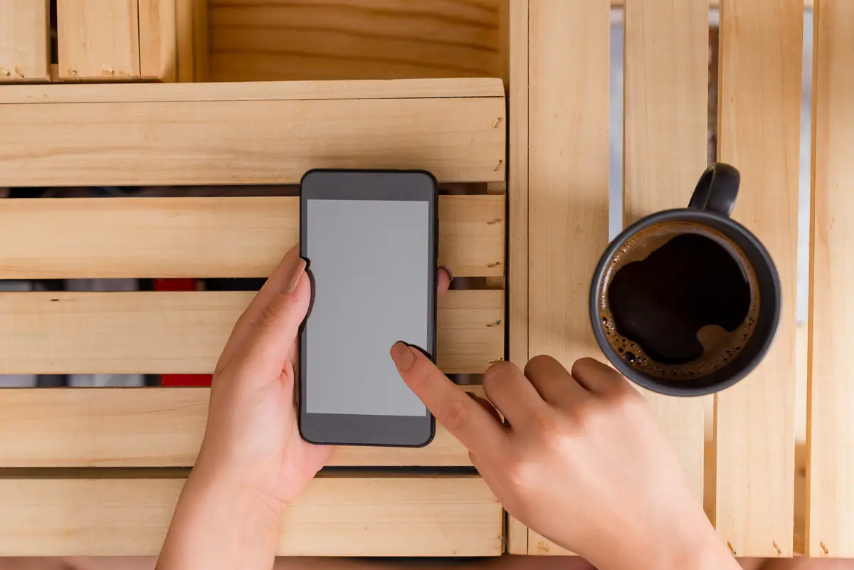 Midsection of woman using mobile phone on table