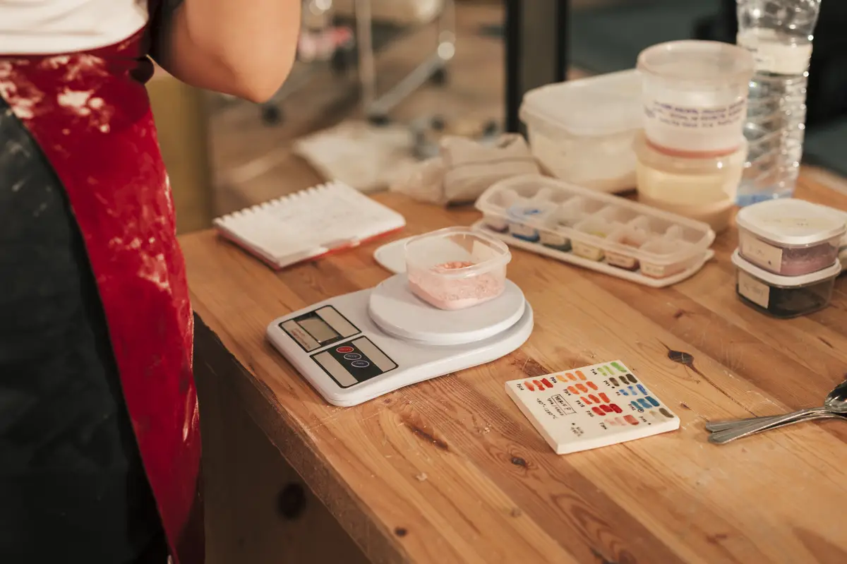 Ceramic color on bowl over the measuring scale on wooden desk
