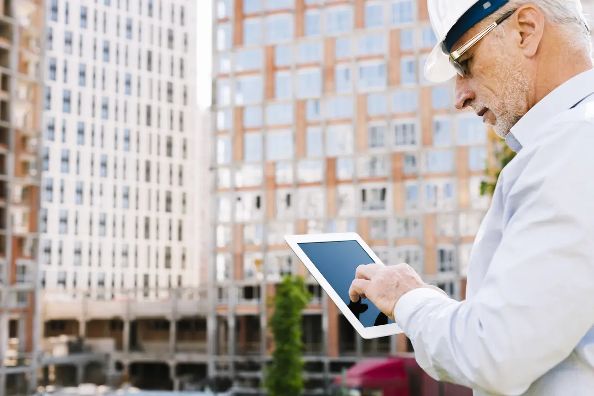 Side view old man looking at a tablet