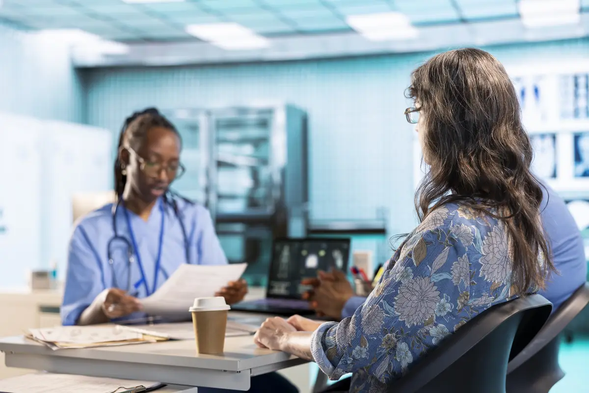 Female nurse and patients reviewing diagnostic results in a medical office