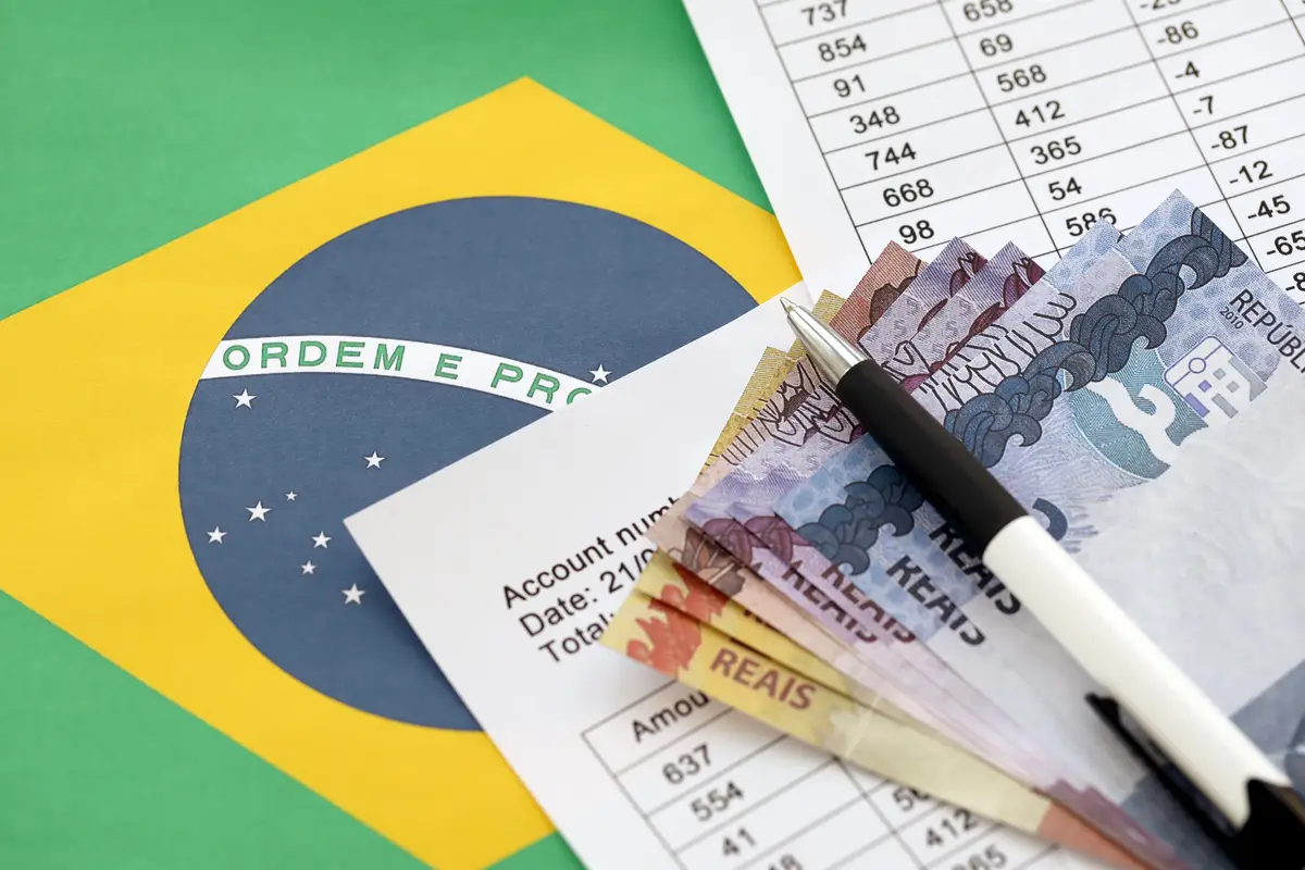 Pen with Brazilian money bills on blank of lottery game Concept of luck and gambling in Brazil