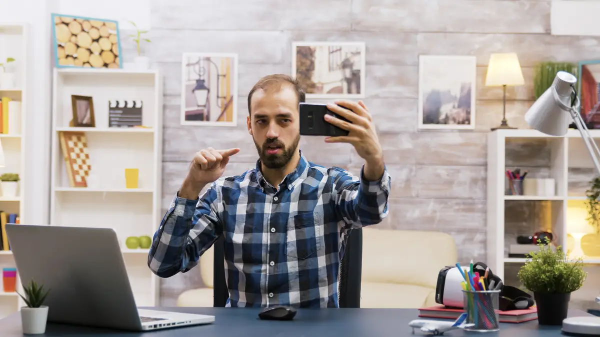 Creative young man using his phone to record a new episode for social media. Famous influencer. Creative content creator.