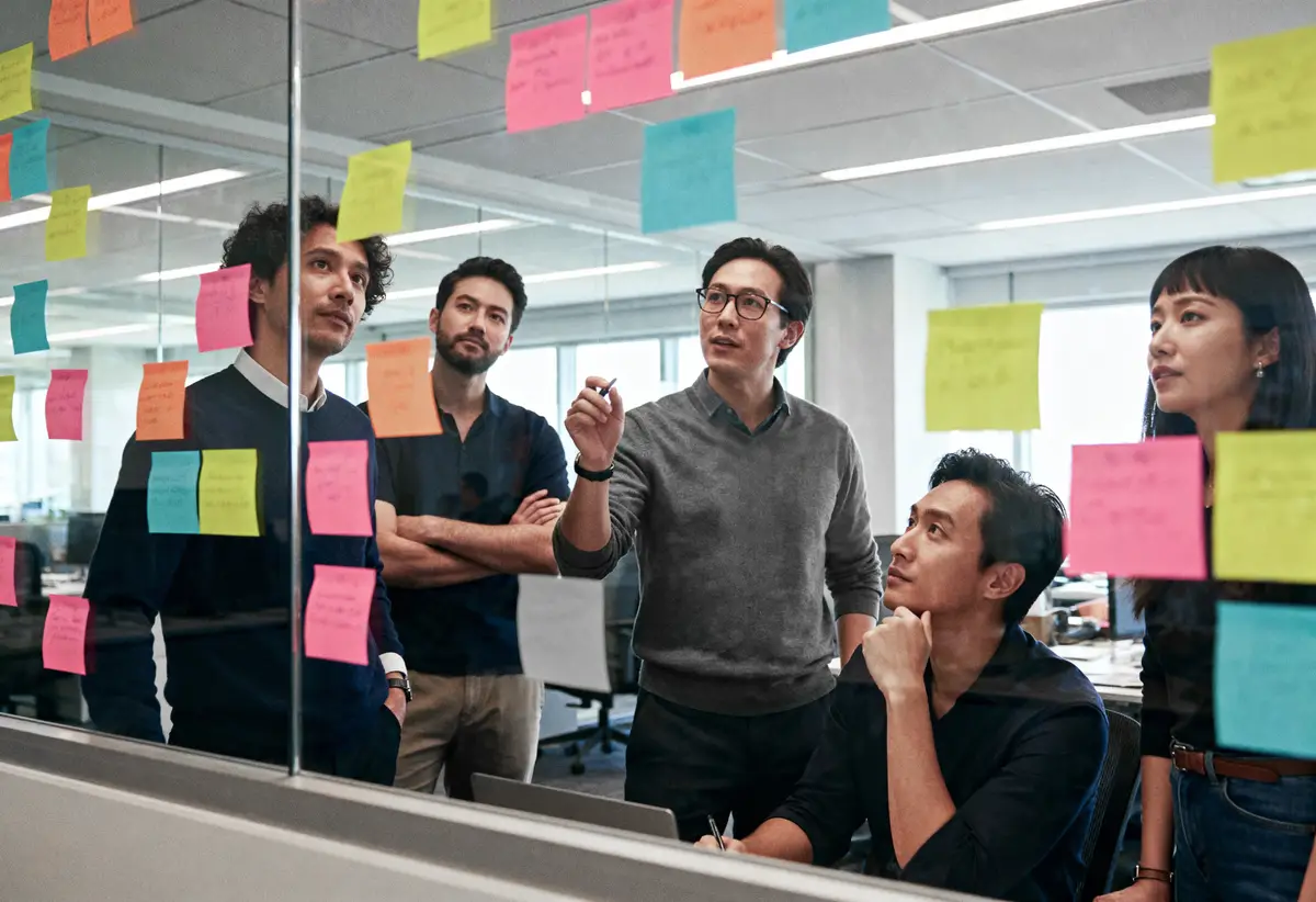 Brainstorming session with sticky notes on glass